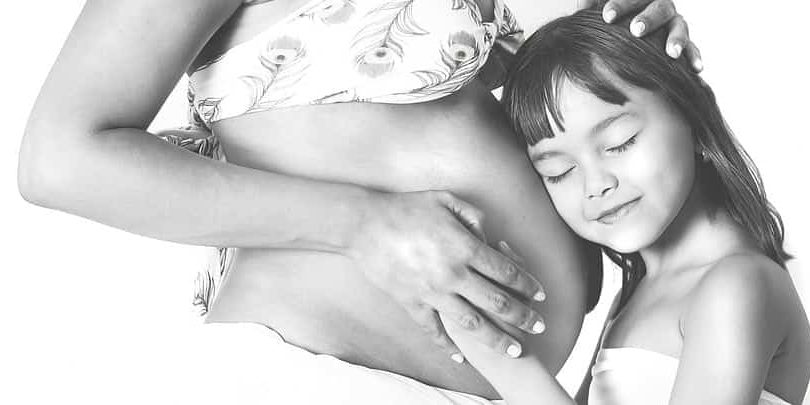 sibling-hugging-mothers-pregnant-stomach.jpg